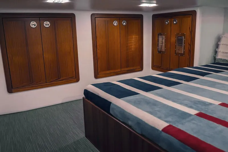 Slide: The Image of Interior of 2027 Lindell 41' yacht with wooden cabinets and striped bedding. - 55