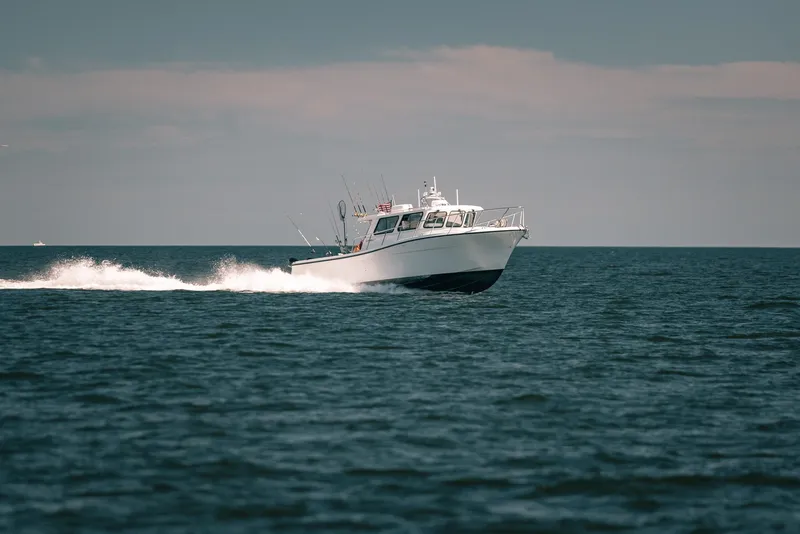 Slide: The Image of 2025 Lindell 41' boat cruising on open water under clear skies. - 6