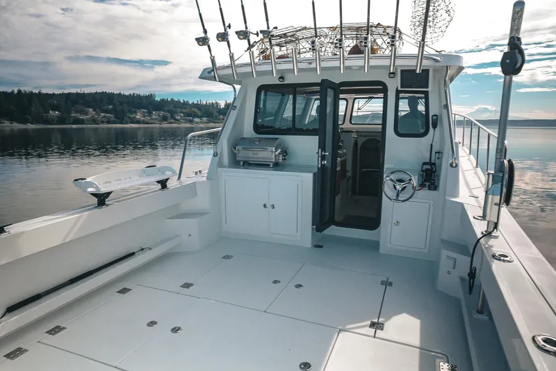 Slide: The Image of 2027 Lindell 41' boat deck with fishing rods, grill, and serene lake view. - 8
