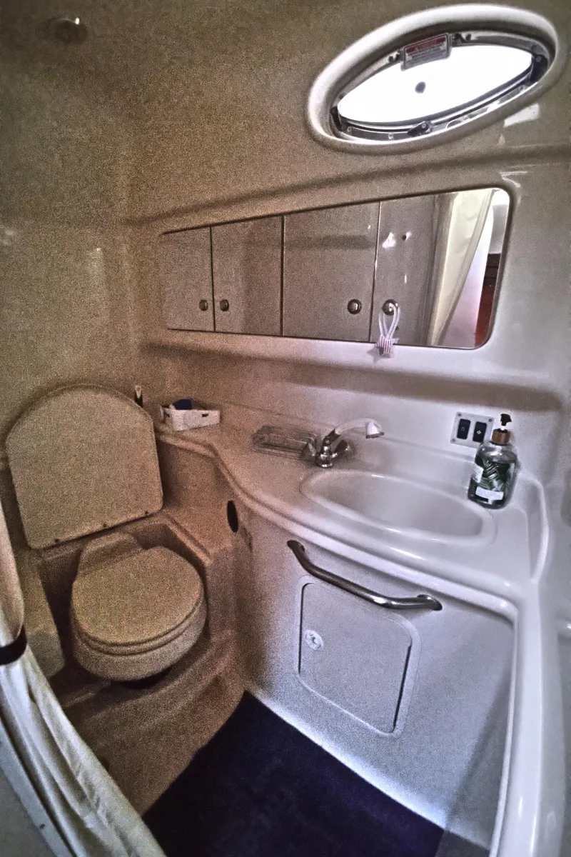 Slide: The Image of 2004 Sea Ray 340 Sundancer bathroom with sink, toilet, and storage cabinets. - 22