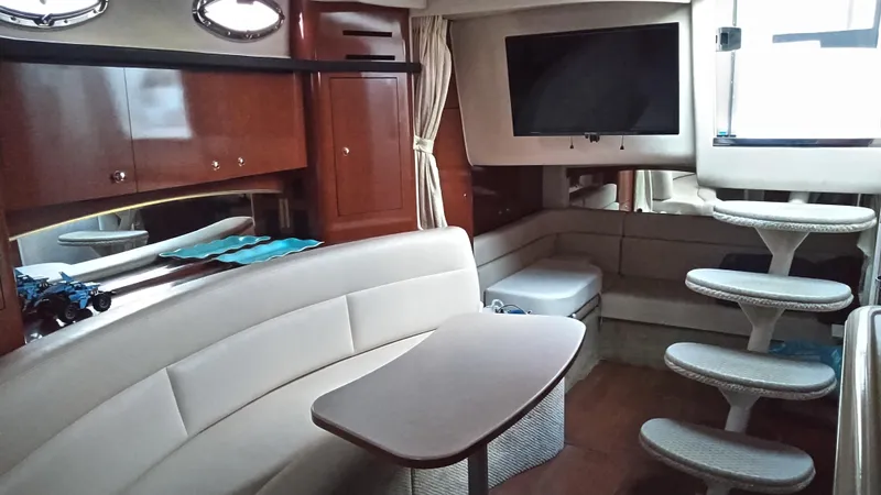 Slide: The Image of Interior of 2004 Sea Ray 340 Sundancer yacht with seating, table, and TV. - 26