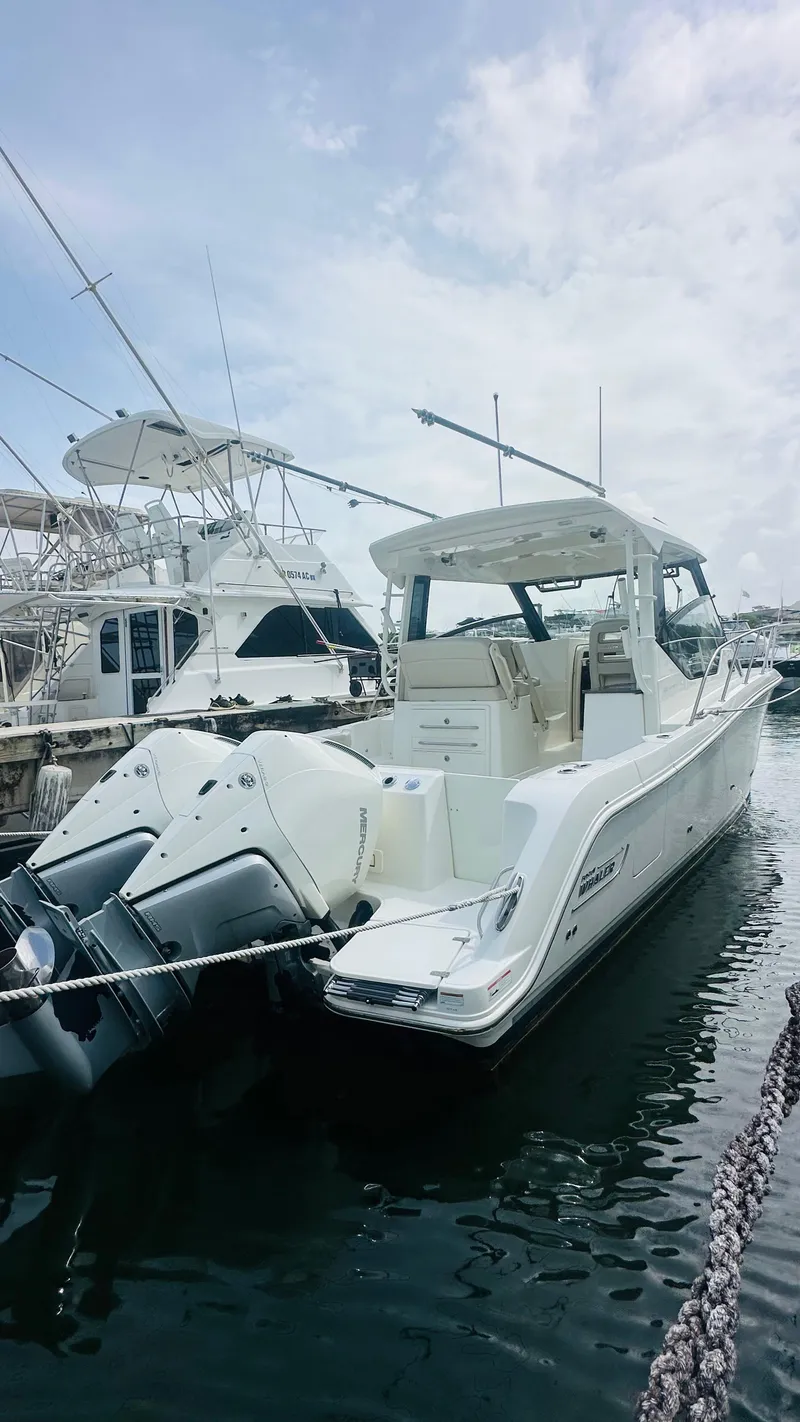 The Image of 2021 Boston Whaler 325 Conquest docked at marina under cloudy sky. - 1