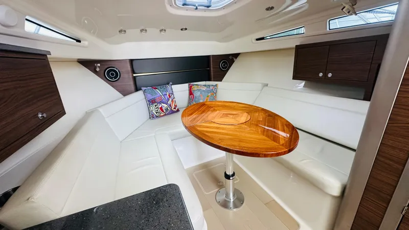 Slide: The Image of Luxurious interior of 2021 Boston Whaler 325 Conquest with wooden table and white seating. - 13