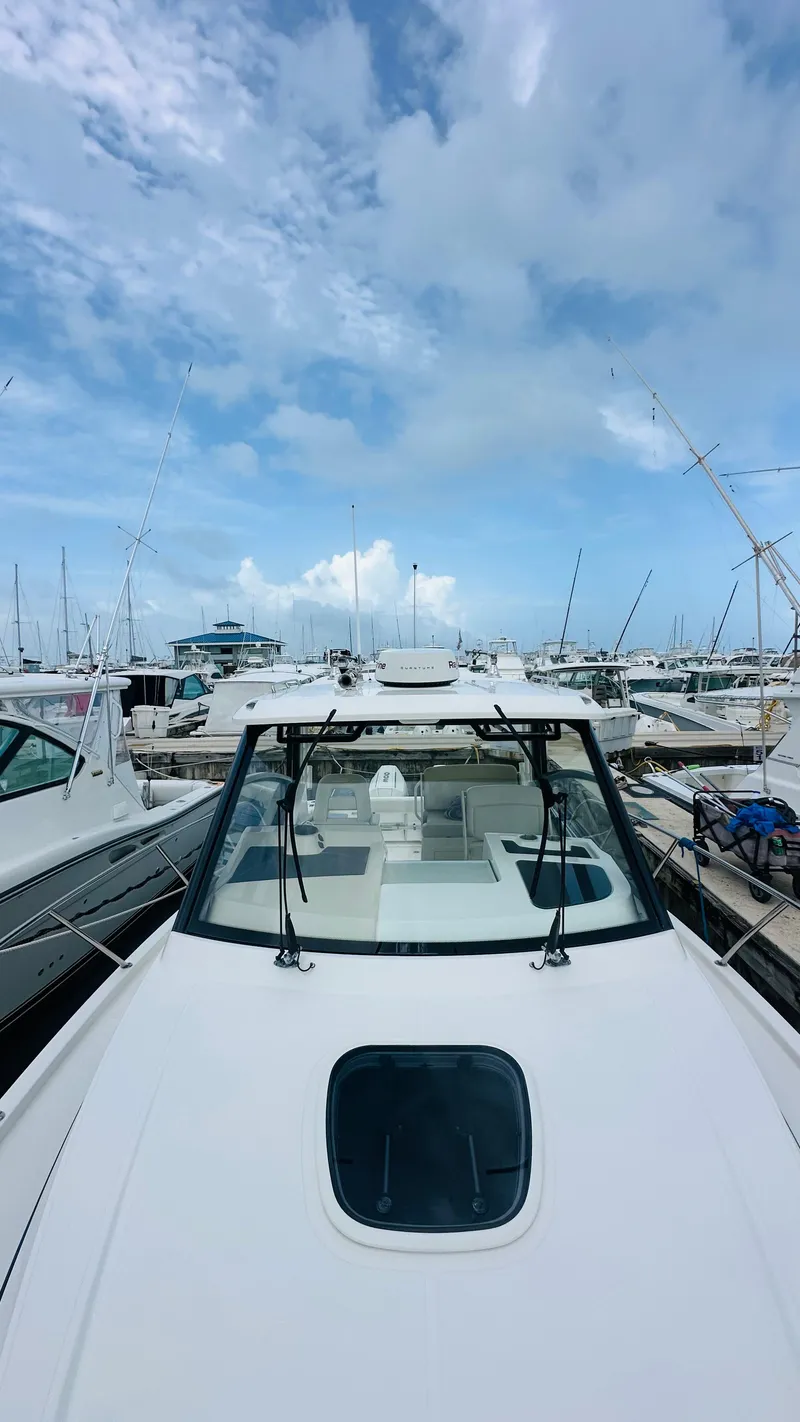 Slide: The Image of 2021 Boston Whaler 325 Conquest docked at marina under blue sky. - 17