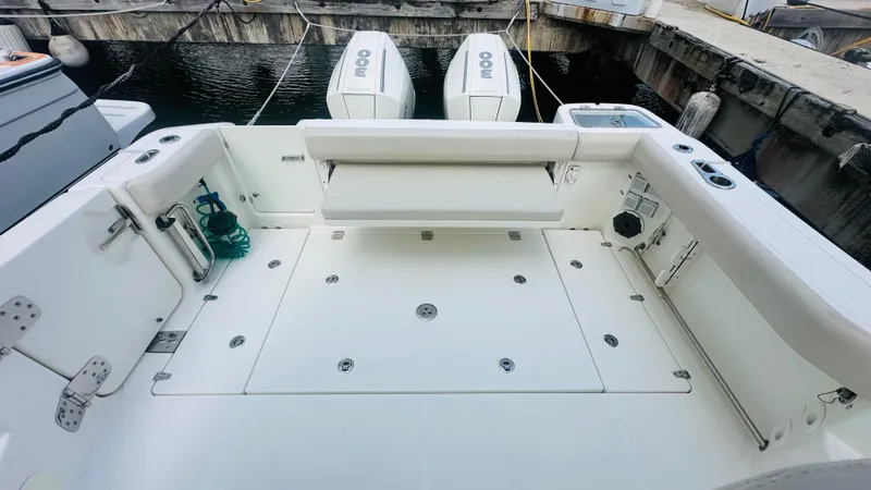 Slide: The Image of 2021 Boston Whaler 325 Conquest boat deck with seating and twin engines at dock. - 3