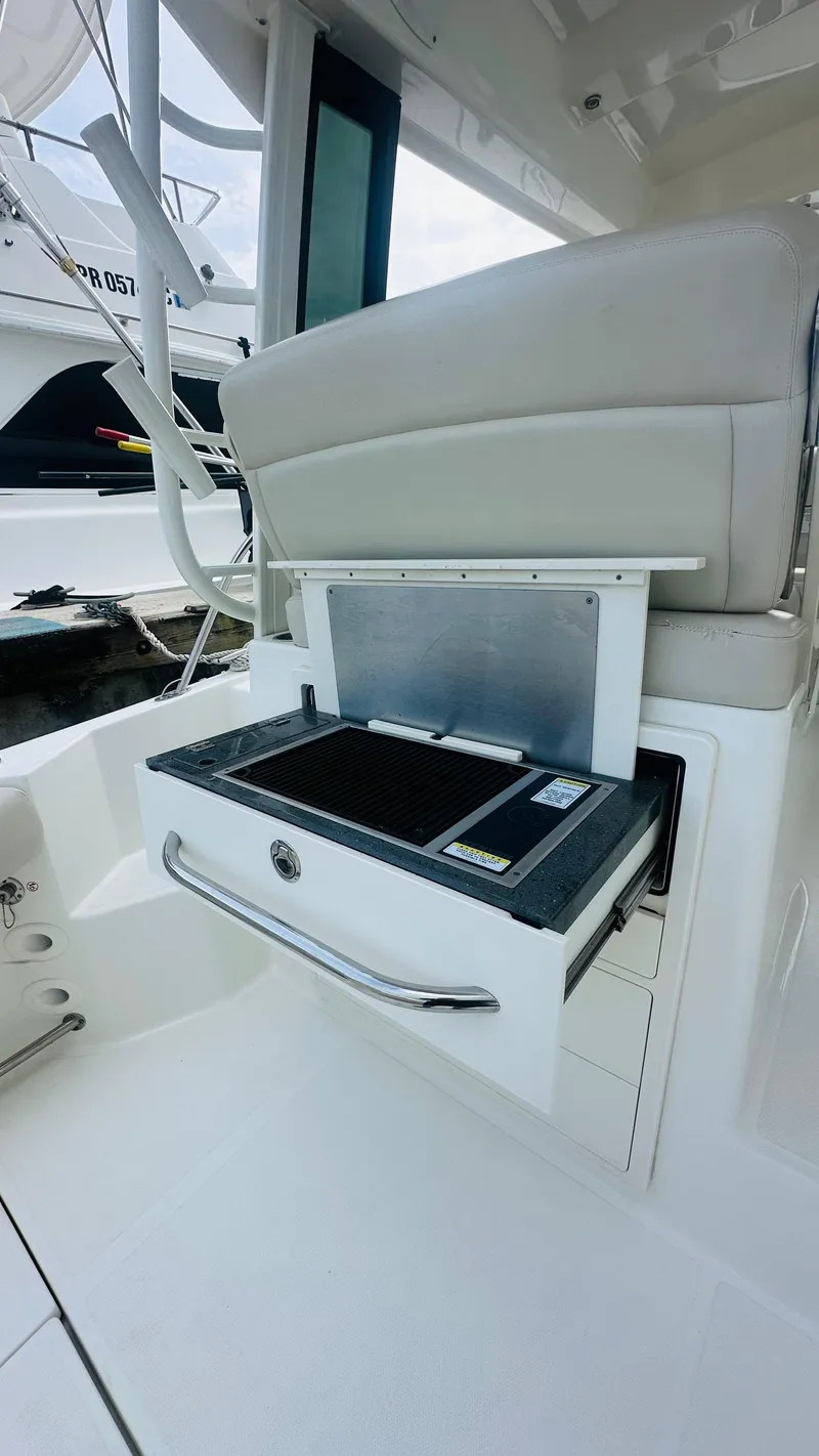 Slide: The Image of 2021 Boston Whaler 325 Conquest boat with built-in grill in cockpit area. - 4