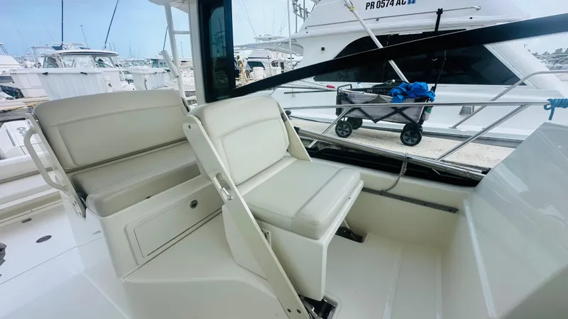 Slide: The Image of 2021 Boston Whaler 325 Conquest interior seating area at a marina. - 5