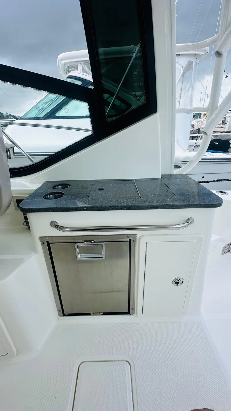 Slide: The Image of 2021 Boston Whaler 325 Conquest boat interior with countertop and storage. - 7