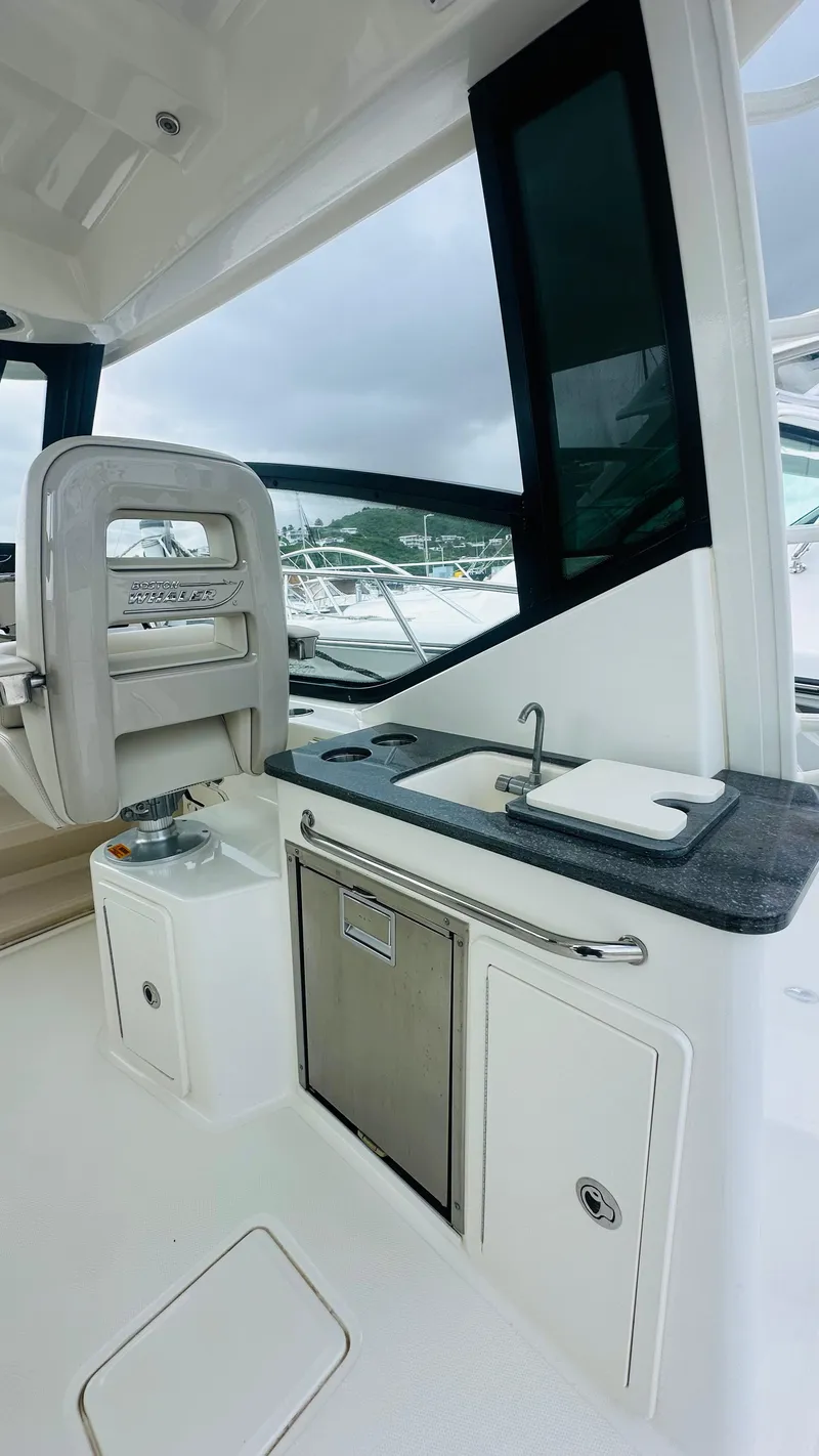 Slide: The Image of 2021 Boston Whaler 325 Conquest interior with sink and seating area. - 8