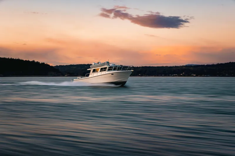 Slide: The Image of 2025 Lindell 42' boat cruising at sunset on calm waters. - 5