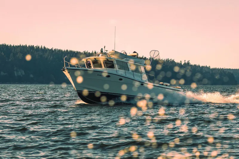 Slide: The Image of 2025 Lindell 42' boat cruising on a scenic lake at sunset. - 6