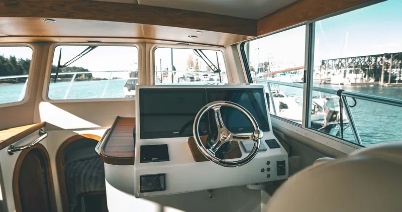 Slide: The Image of Interior of 2025 Lindell 42' yacht with modern helm and scenic marina view. - 7