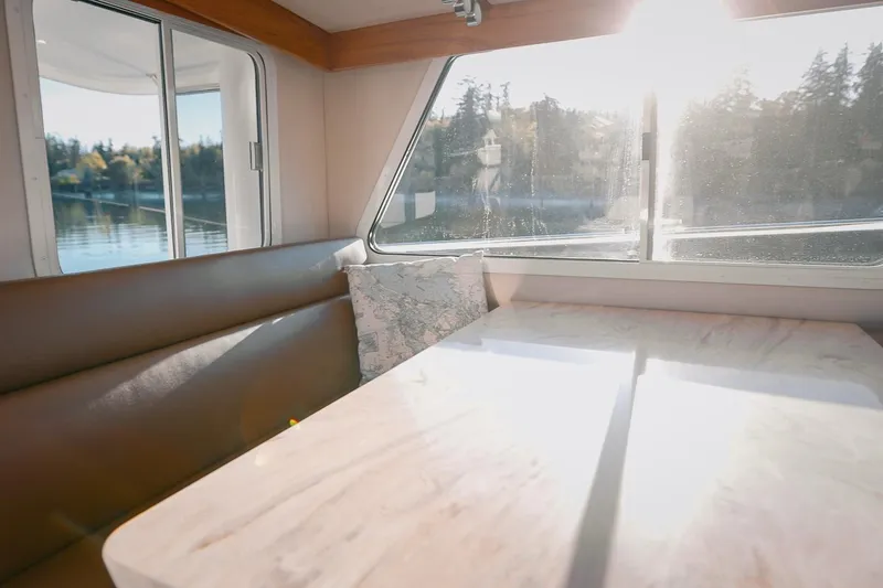 Slide: The Image of Interior of 2027 Lindell 42' boat with sunlit dining area and scenic window view. - 24