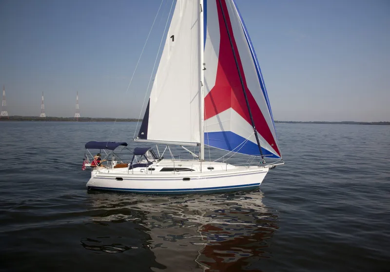 Slide: The Image of 2024 Catalina 355 sailboat with colorful sails on calm water. - 15