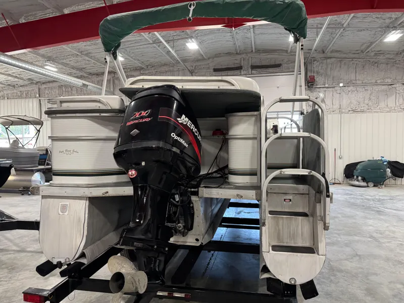 Slide: The Image of 2001 PlayCraft 2600 Powertoon pontoon boat with Mercury 200 Optimax engine in storage. - 5