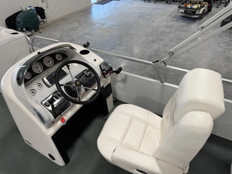 Slide: The Image of 2001 PlayCraft 2600 Powertoon boat console with steering wheel and white captain's chair. - 6