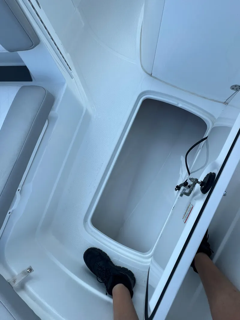 Slide: The Image of 2020 Tahoe 2150 CC boat interior with open storage compartment and seating. - 19