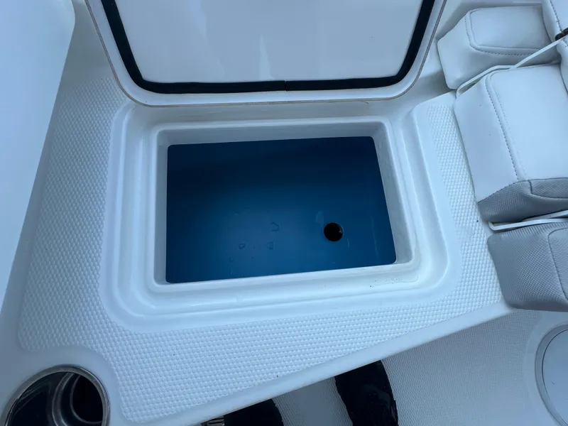 Slide: The Image of Open storage compartment on a 2020 Tahoe 2150 CC boat, featuring white interior. - 25