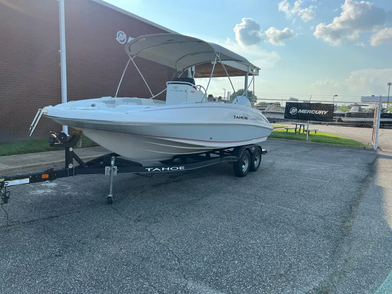 Slide: The Image of 2020 Tahoe 2150 CC boat on trailer, parked outdoors under a clear sky. - 4