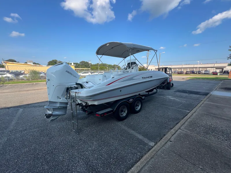 Slide: The Image of 2020 Tahoe 2150 CC boat on trailer, parked outdoors under a clear blue sky. - 8