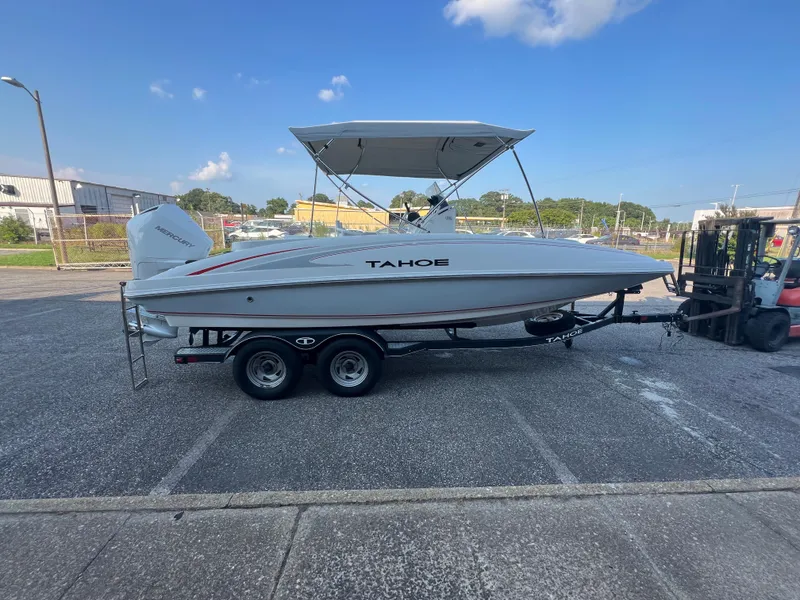 Slide: The Image of 2020 Tahoe 2150 CC boat on trailer, parked outdoors under clear blue sky. - 9
