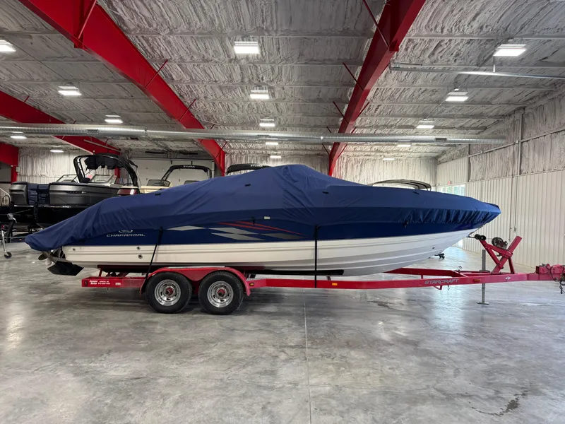 Slide: The Image of 2005 Chaparral 260 SSi boat covered in blue tarp on red trailer indoors. - 11