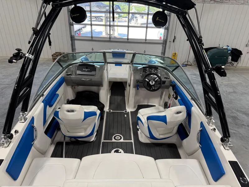 Slide: The Image of 2018 Chaparral 21 H2O boat interior with blue and white seating, steering wheel, and dashboard. - 6