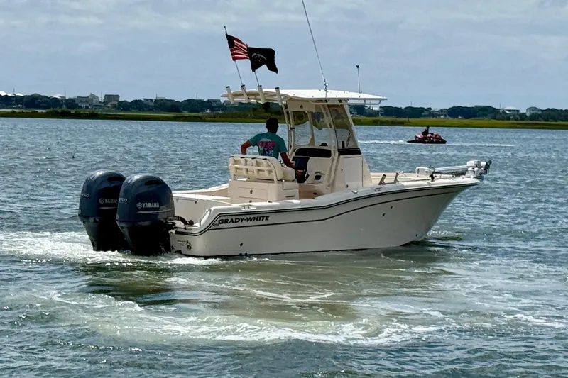Slide: The Image of 2020 Grady-White Fisherman 257 boat cruising on a lake with dual Yamaha engines. - 5