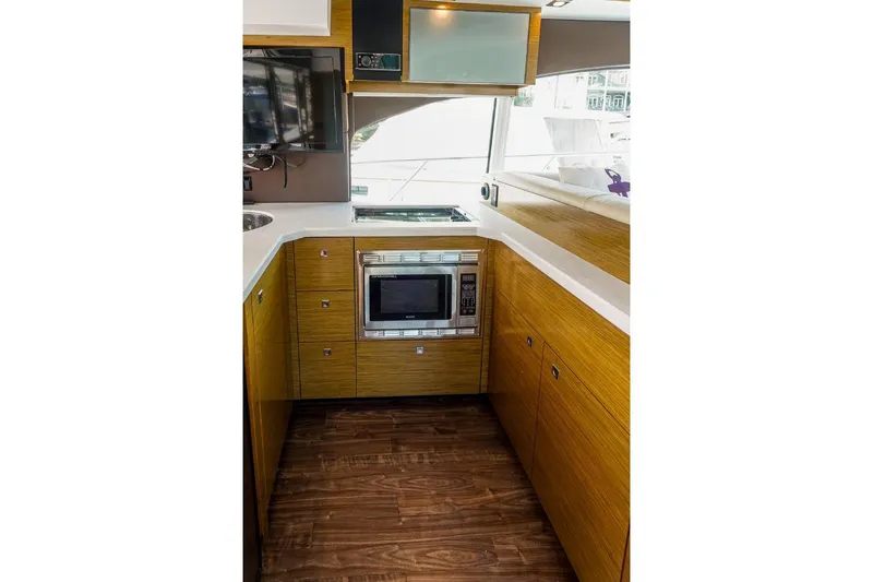 Slide: The Image of Modern kitchen interior of 2016 Cruisers Yachts 45 Cantius with wood cabinetry and appliances. - 21