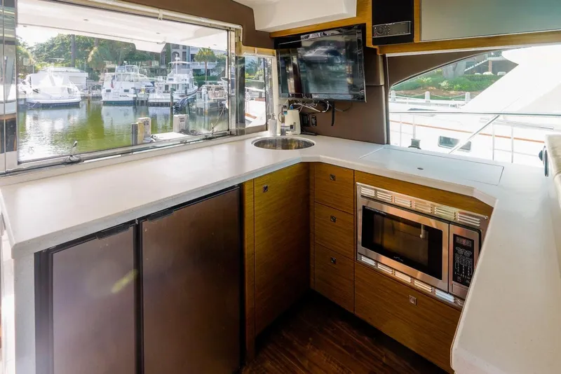 Slide: The Image of Modern kitchen interior of 2016 Cruisers Yachts 45 Cantius with appliances and marina view. - 22