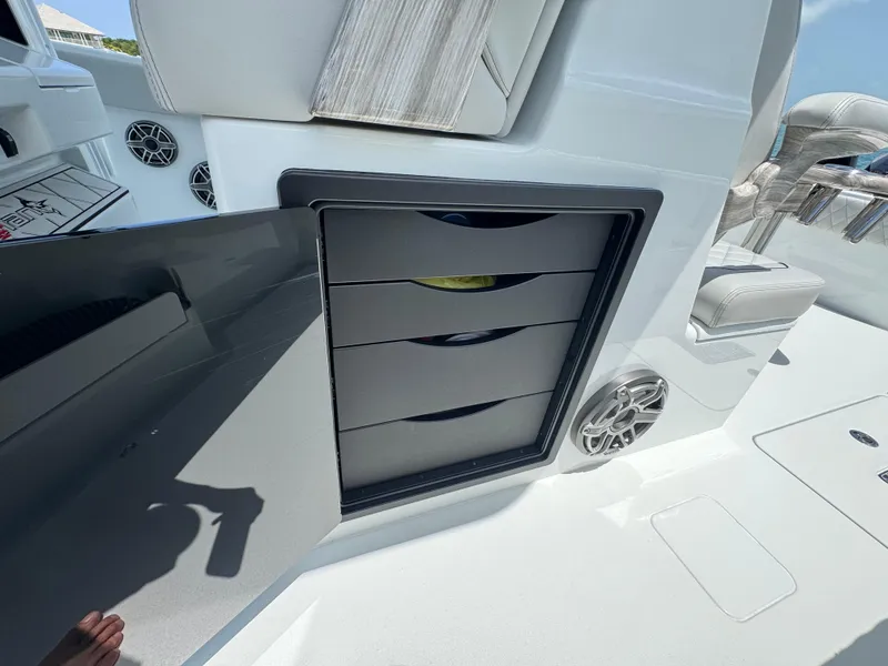 Slide: The Image of Open storage compartment on Freeman 38 boat, featuring multiple drawers and speaker, 2025 model. - 34