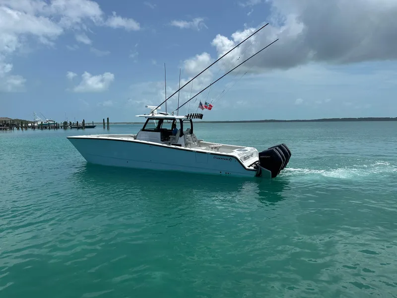 Slide: The Image of 2025 Freeman 38 boat cruising on turquoise water under a partly cloudy sky. - 4