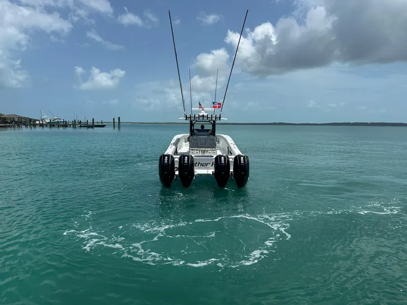 Slide: The Image of Freeman 38 boat on turquoise water, 2025 model, with four engines and clear sky. - 6