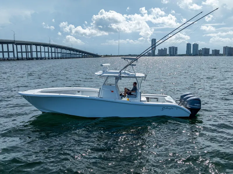 Slide: The Image of 2021 Yellowfin 34 boat on water near a bridge and city skyline. - 12