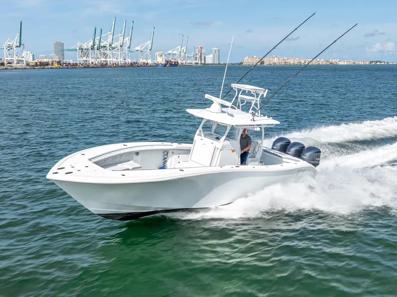 Slide: The Image of 2021 Yellowfin 34 boat cruising on water near industrial port. - 13