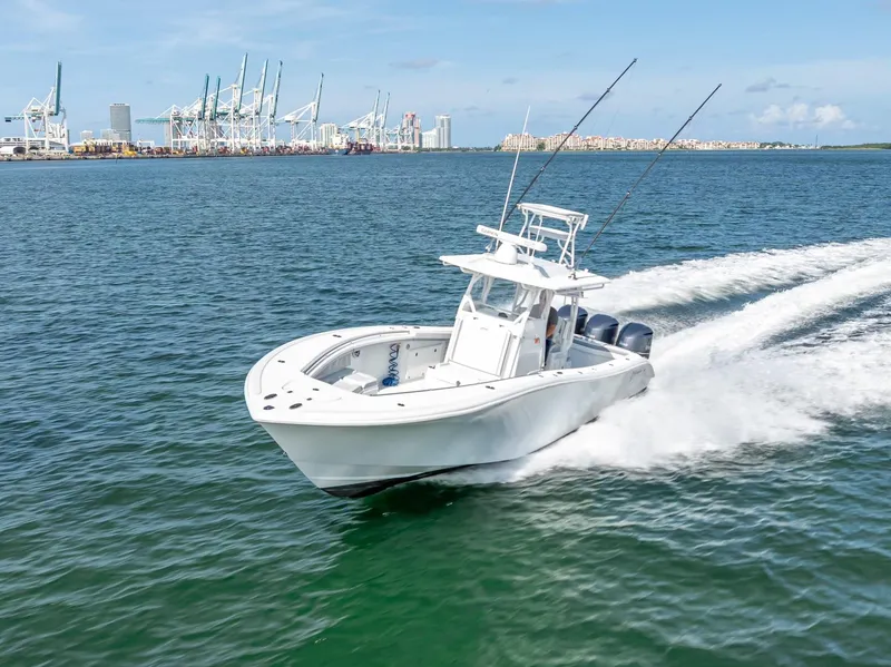 Slide: The Image of 2021 Yellowfin 34 boat cruising near a port with cranes in the background. - 14