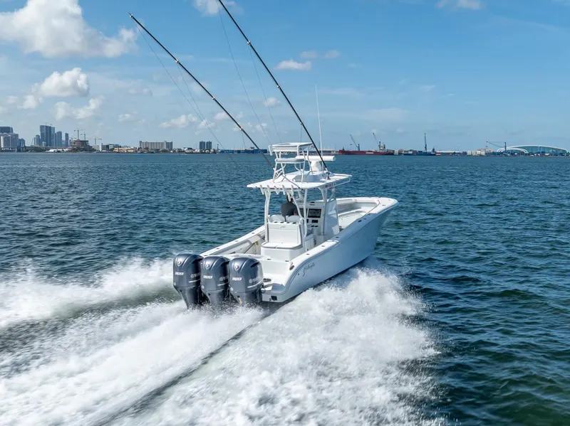 Slide: The Image of 2021 Yellowfin 34 boat cruising on open water with city skyline in background. - 16