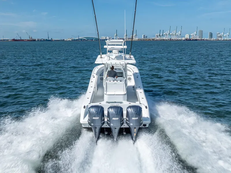Slide: The Image of 2021 Yellowfin 34 boat cruising on open water with city skyline in background. - 17