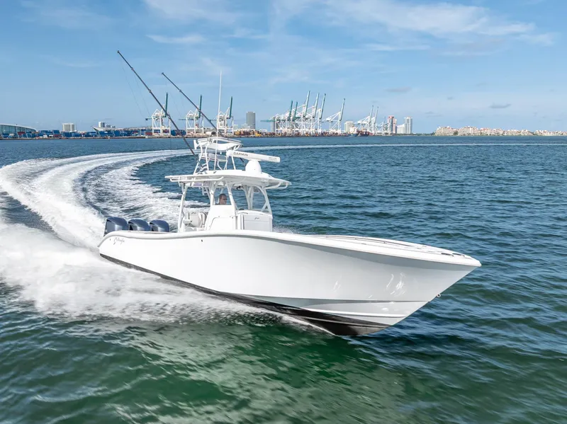 Slide: The Image of 2021 Yellowfin 34 boat cruising on open water near a port city skyline. - 20