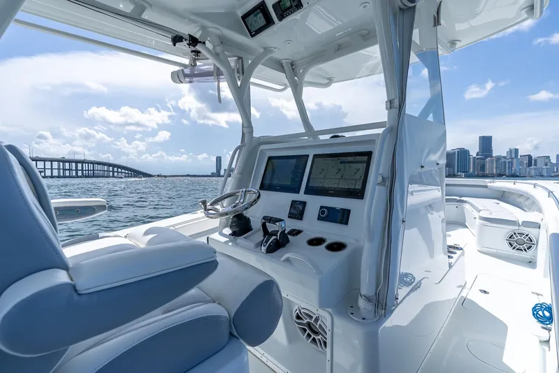 Slide: The Image of 2021 Yellowfin 34 boat interior with modern dashboard, city skyline, and bridge in background. - 26