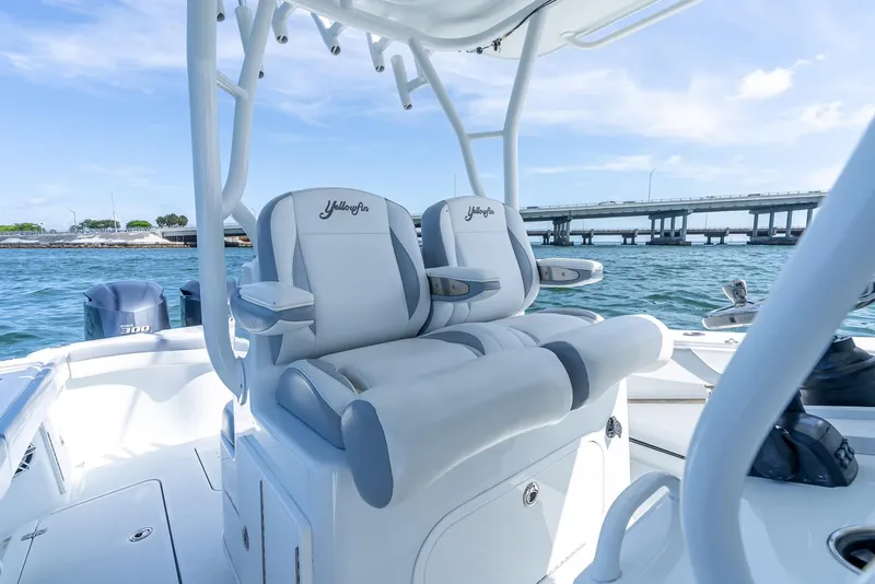 Slide: The Image of 2021 Yellowfin 34 boat interior with dual seats, ocean view, and bridge in background. - 32