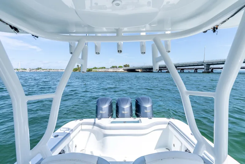 Slide: The Image of 2021 Yellowfin 34 boat with triple engines on open water near a bridge. - 34
