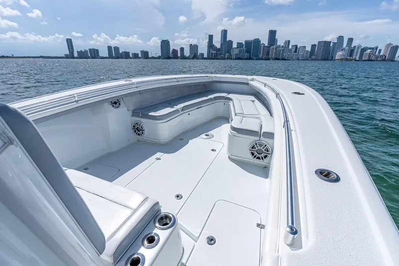 Slide: The Image of 2021 Yellowfin 34 boat with spacious seating, ocean view, and city skyline in the background. - 35