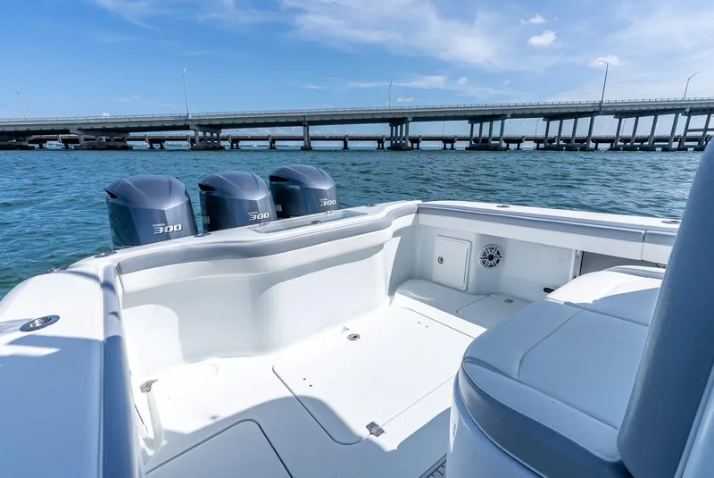 Slide: The Image of 2021 Yellowfin 34 boat with triple Yamaha 300 engines on open water near a bridge. - 43