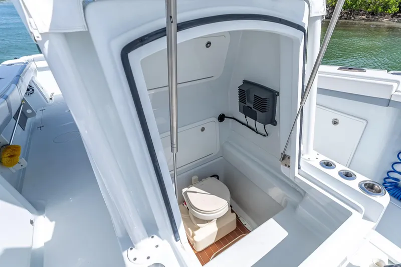 Slide: The Image of 2021 Yellowfin 34 boat interior with compact marine toilet and storage area. - 48