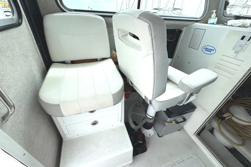 Slide: The Image of Interior of 2021 Parker 2520 XLD Sport Cabin with two white seats and control panel. - 18