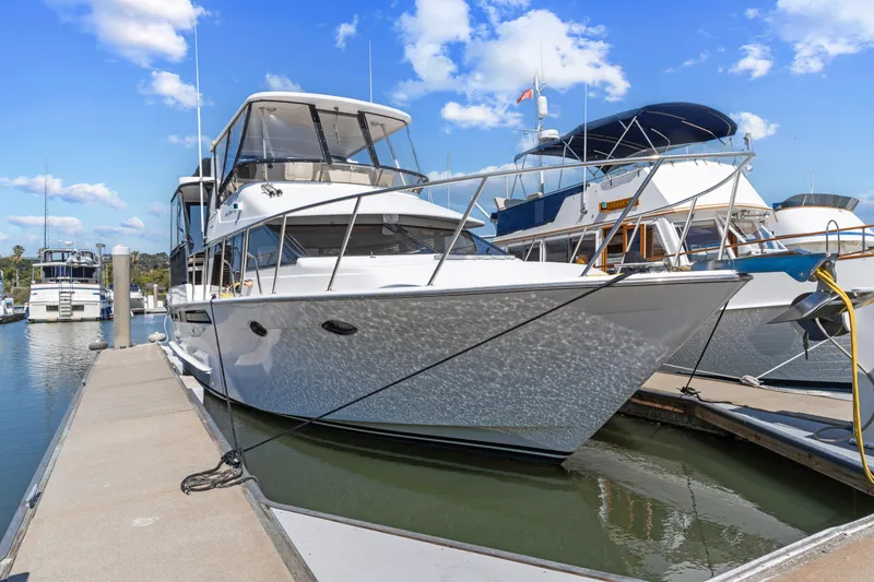 The Image of Ocean Alexander 440 yacht, 1993 model, docked at marina under blue sky. - 1