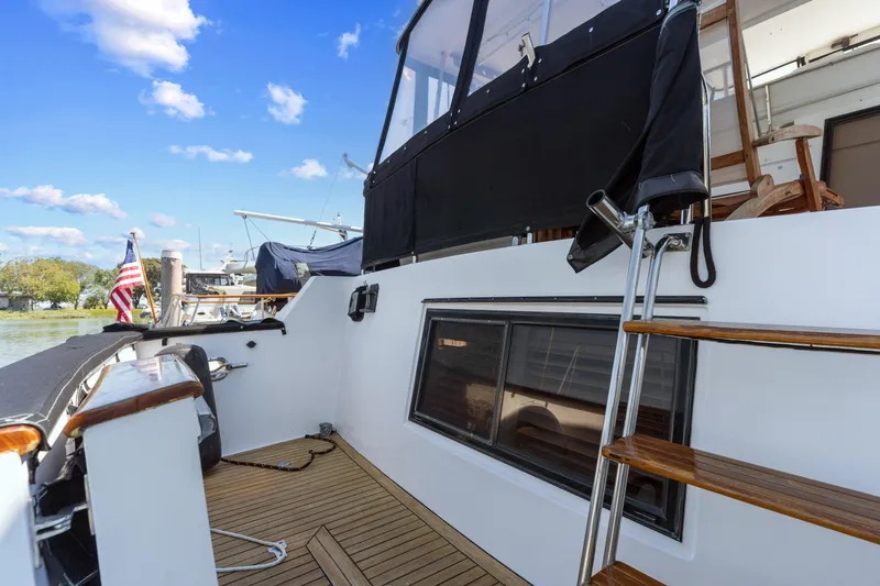 Slide: The Image of 1993 Ocean Alexander 440 yacht deck with wooden steps and American flag. - 10