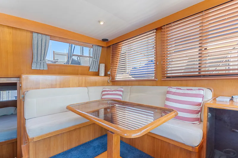 Slide: The Image of Interior of 1993 Ocean Alexander 440 yacht with cozy dining area and striped cushions. - 18