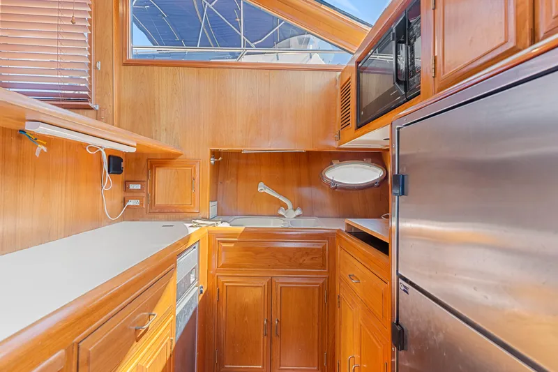 Slide: The Image of Kitchen area of a 1993 Ocean Alexander 440 yacht with wooden cabinetry and stainless steel appliances. - 19